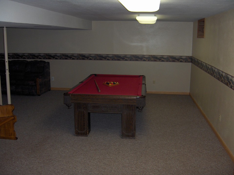 finished basement with pool table.