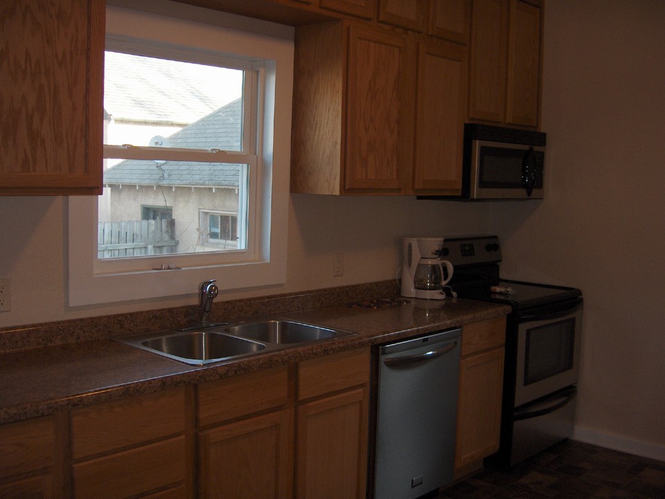brand new kitchen new cupboards, countertops, fixtures, flooring, stainless dishwasher, microwave, stove, and refrigerator