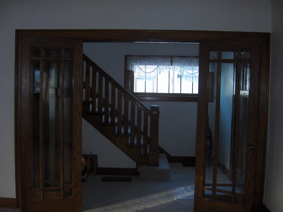 french doors from formal room to the open stairway.