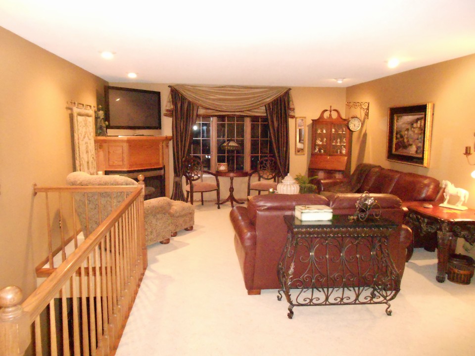 main floor living room with fireplace open stairs to basement