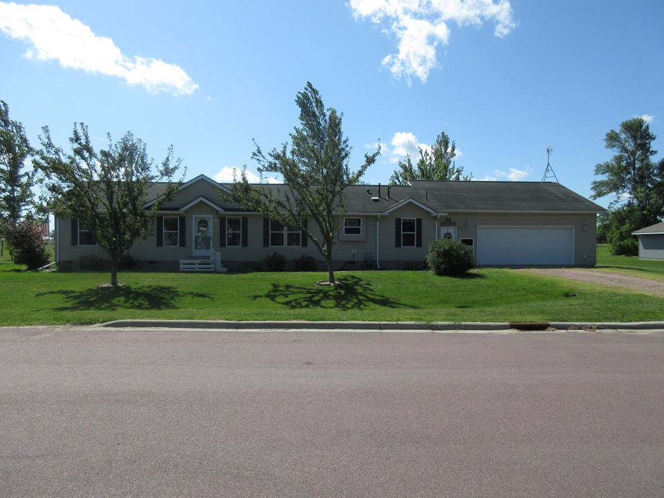 front of home very nice curb appeal with vinyl siding, flowering trees, nice landscaping, and a huge garage.