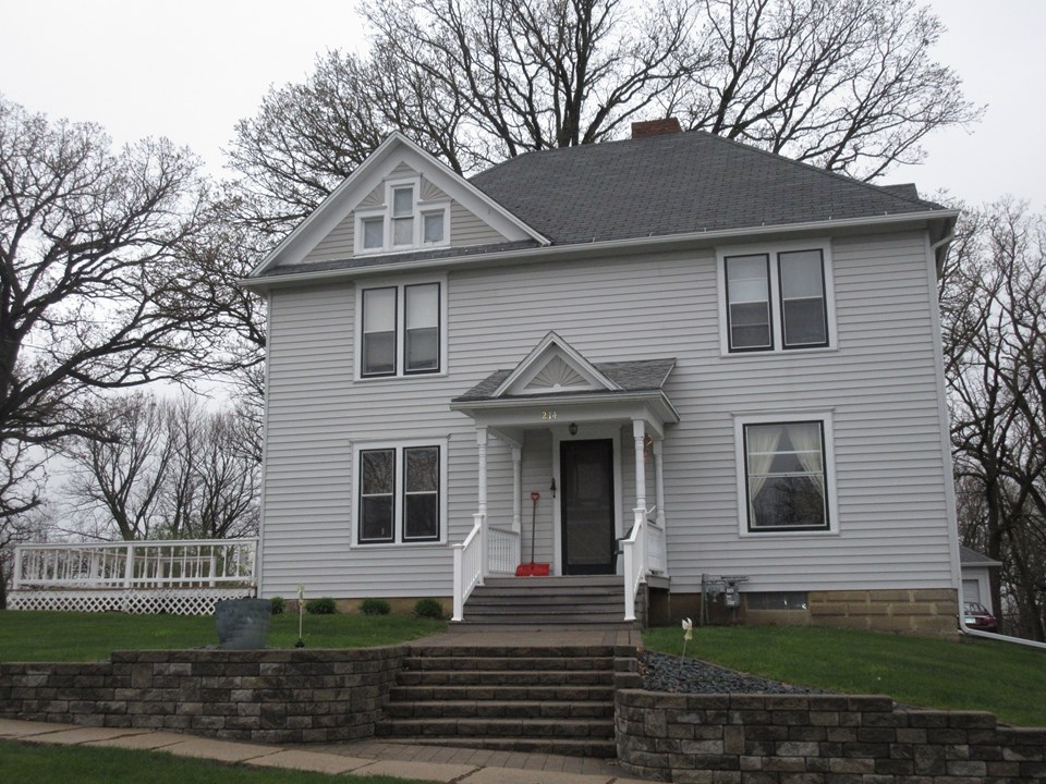 front of home vinyl siding, nice deck, new storm windows and screens, beautiful landscaping