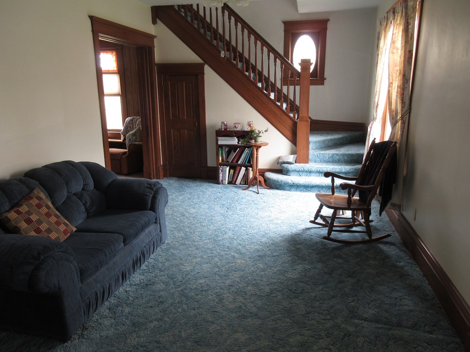 living room doors to the den and open stairway to upstairs