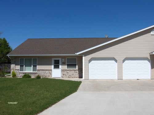 front of duplex  two car garage and huge driveway.