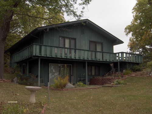 back of house with walk out basement and wrap around deck