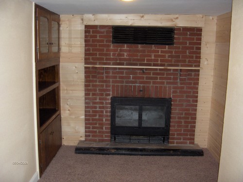 firplace and display cabinet knotty pine wall and new flooring.