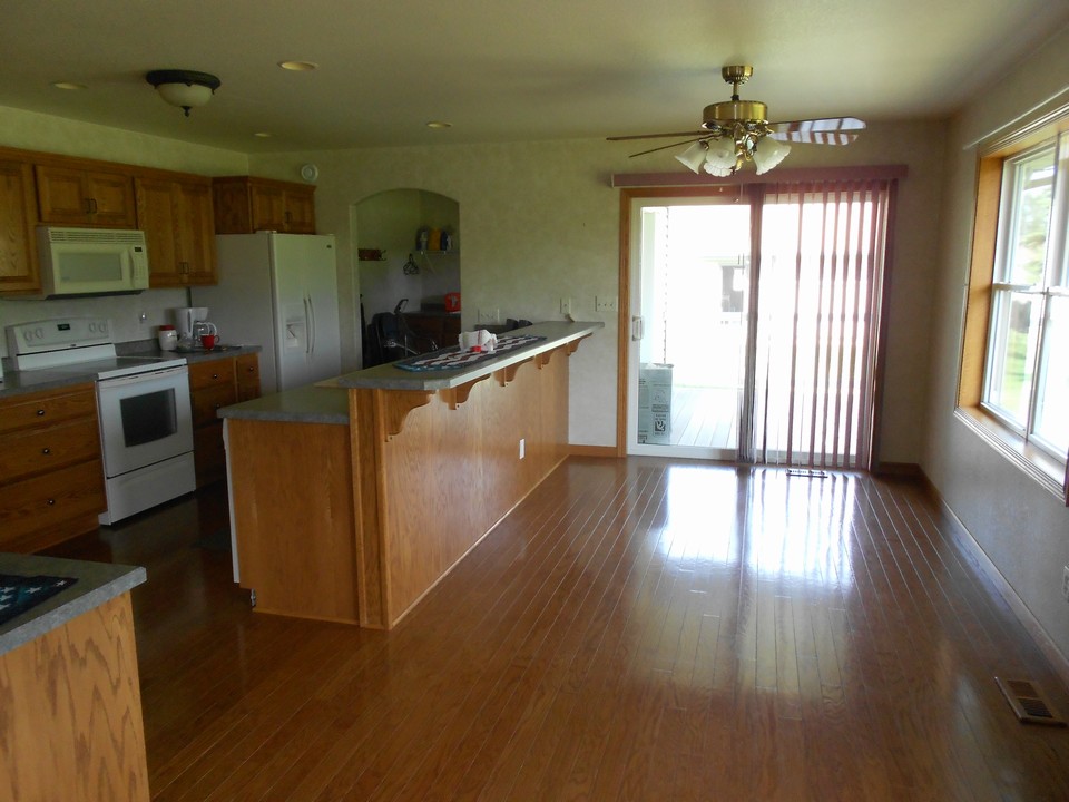large kitchen and breakfast bar hardwood floors, patio, lots of cupboards