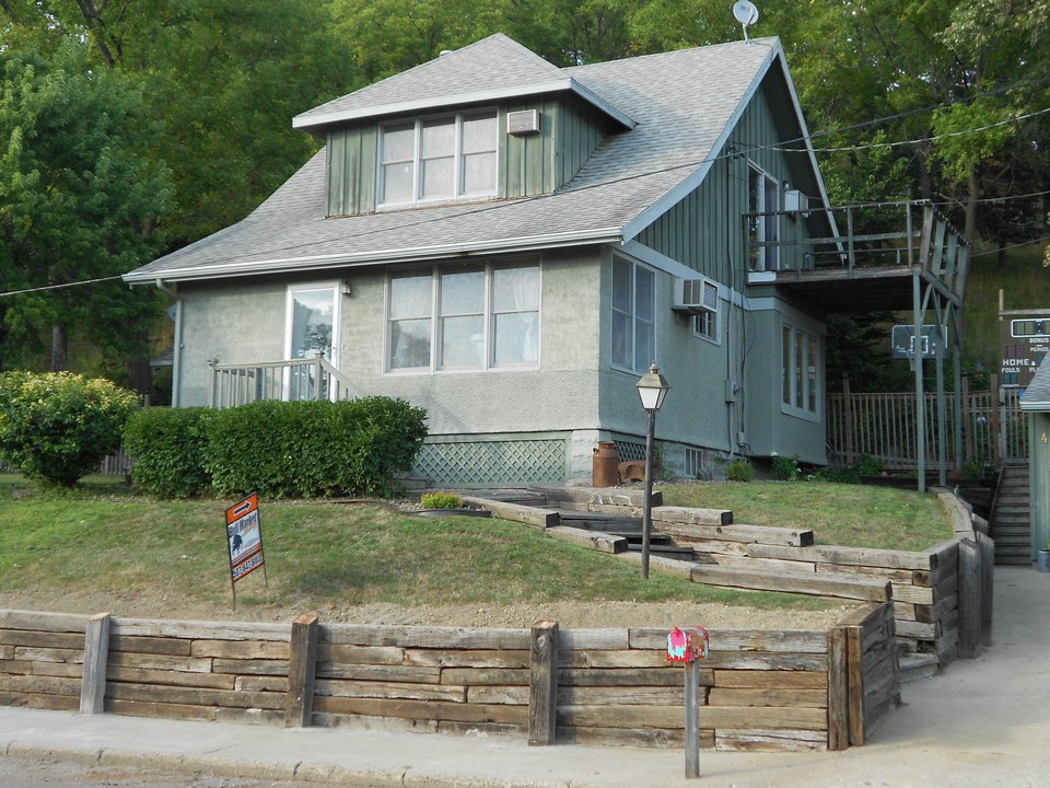 front of home sitting on a hill overlooking the park and the river
