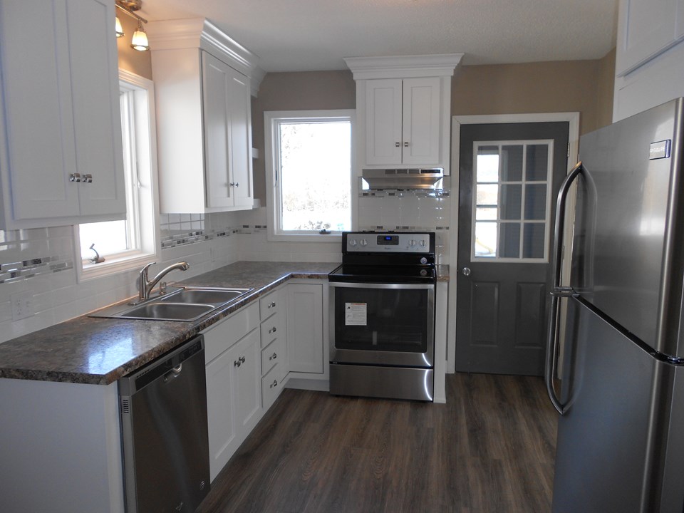new kitchen stainless steel whirlpool stove and dishwasher. frigidaire fridge. koch cabinets. hi def laminate countertops. pergo flooring. nice hardware. lazy susan in the corner. stainless steel sink. tile backsplash.