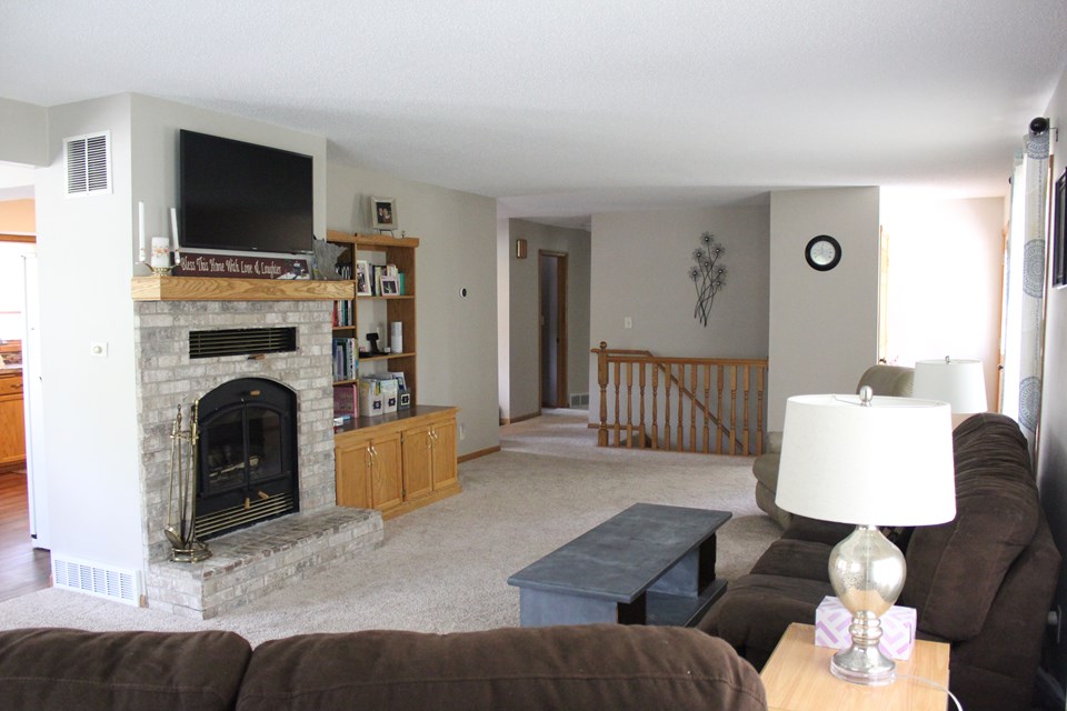 living room wood burning fireplace. open stairway to family room. open to the dining room and kitchen.