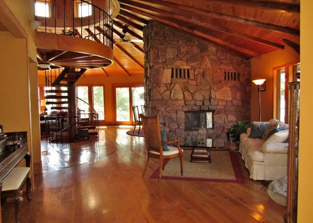 main floor one of two living rooms. jasper granite two sided fireplace. round cathedral ceilings.