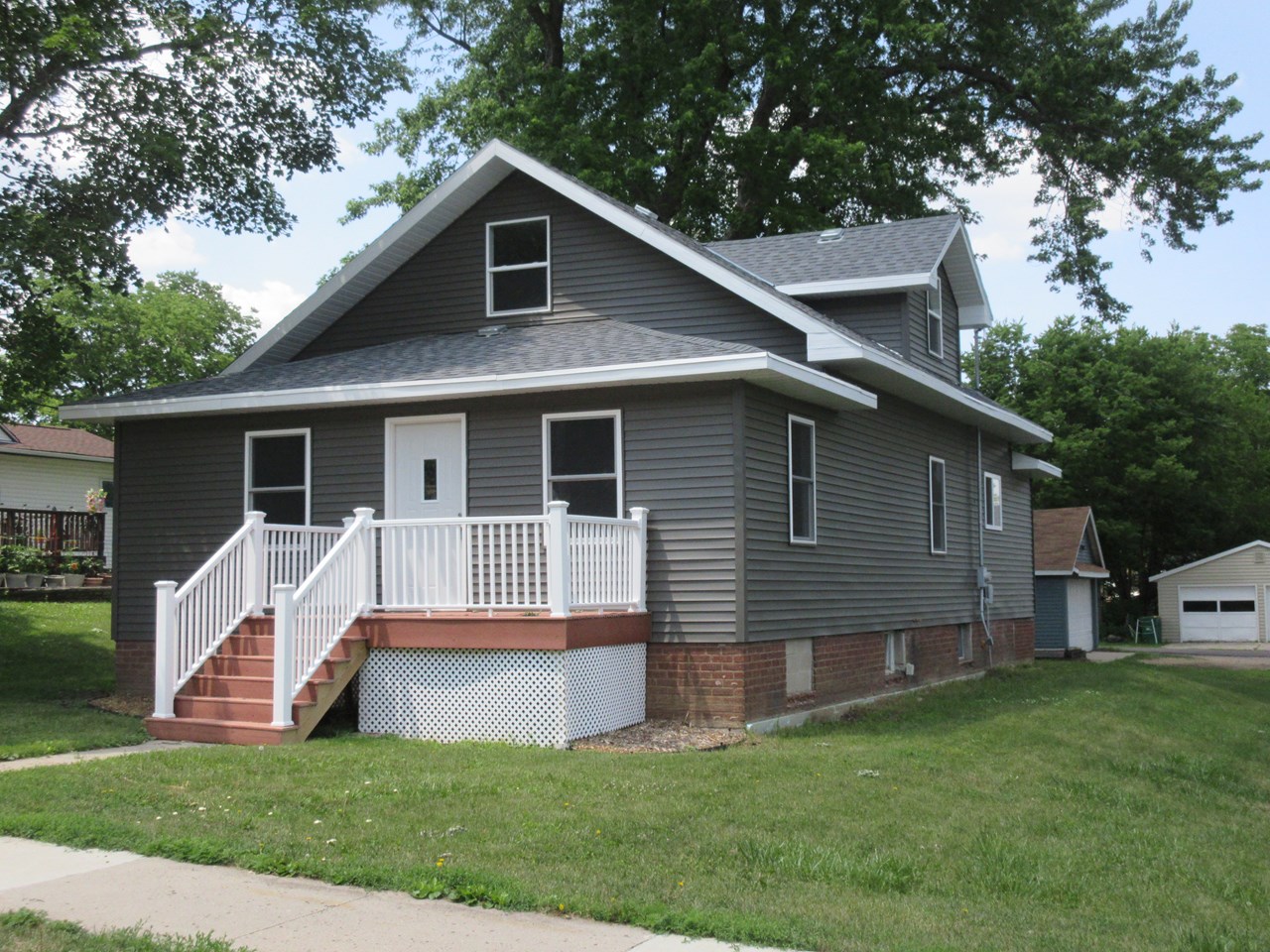 front of home permanent decking and railing. new roof, windows, soffit, fascia, doors.