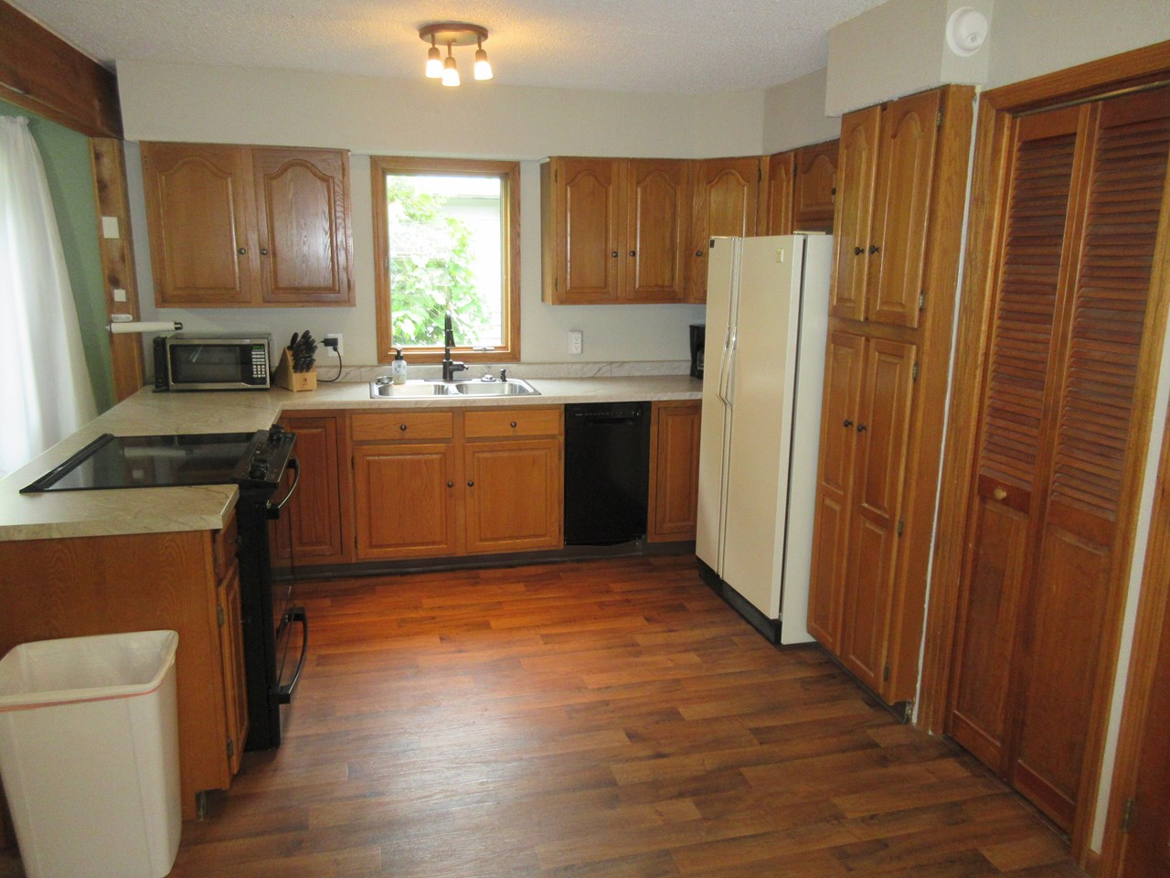 kitchen newer countertop, sink, stove, and dishwasher