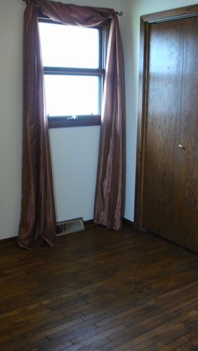 one of three bedrooms hardwood floor, closet, and window.