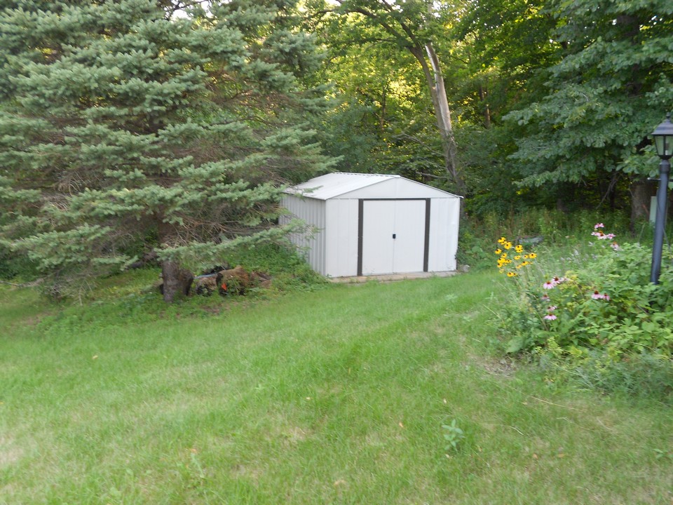 back yard utility shed with a cement floor