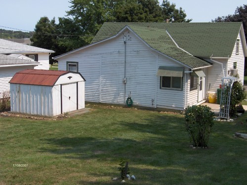 back of house with storage shed
