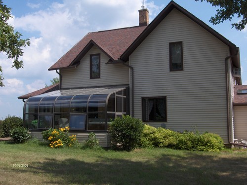 side of house sun room with a hot tub.
