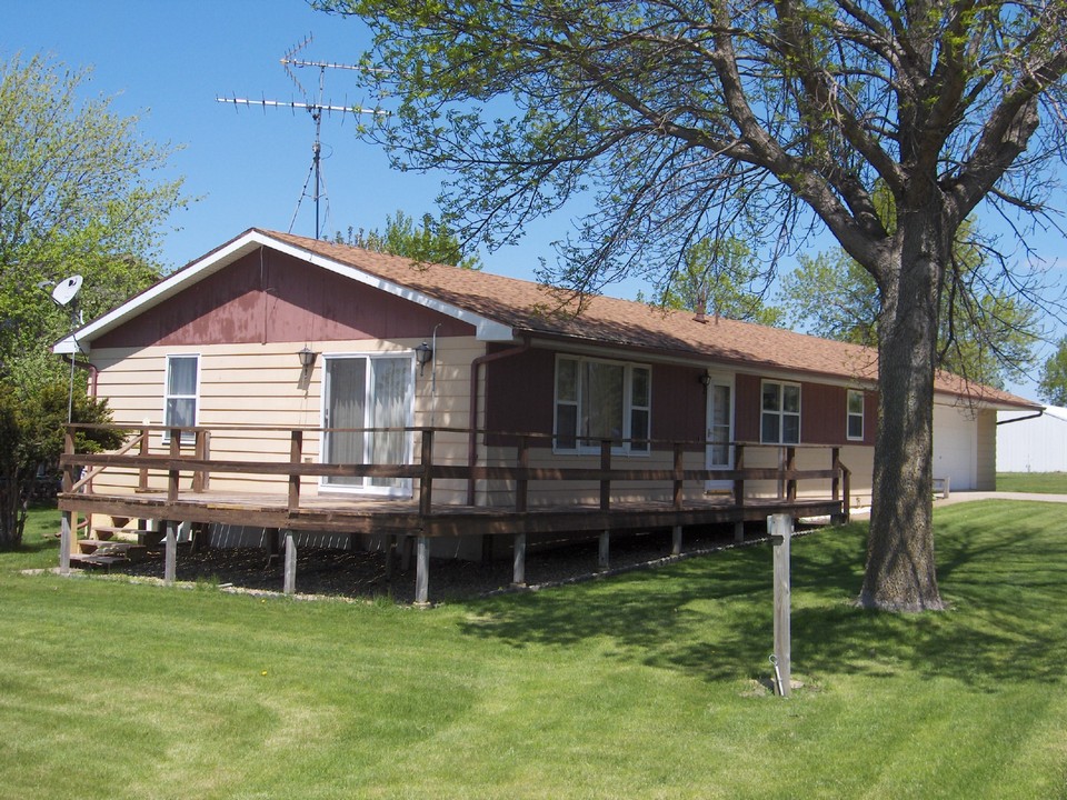 front of house taken from near the lake.  wrap around deck and nice lawn.