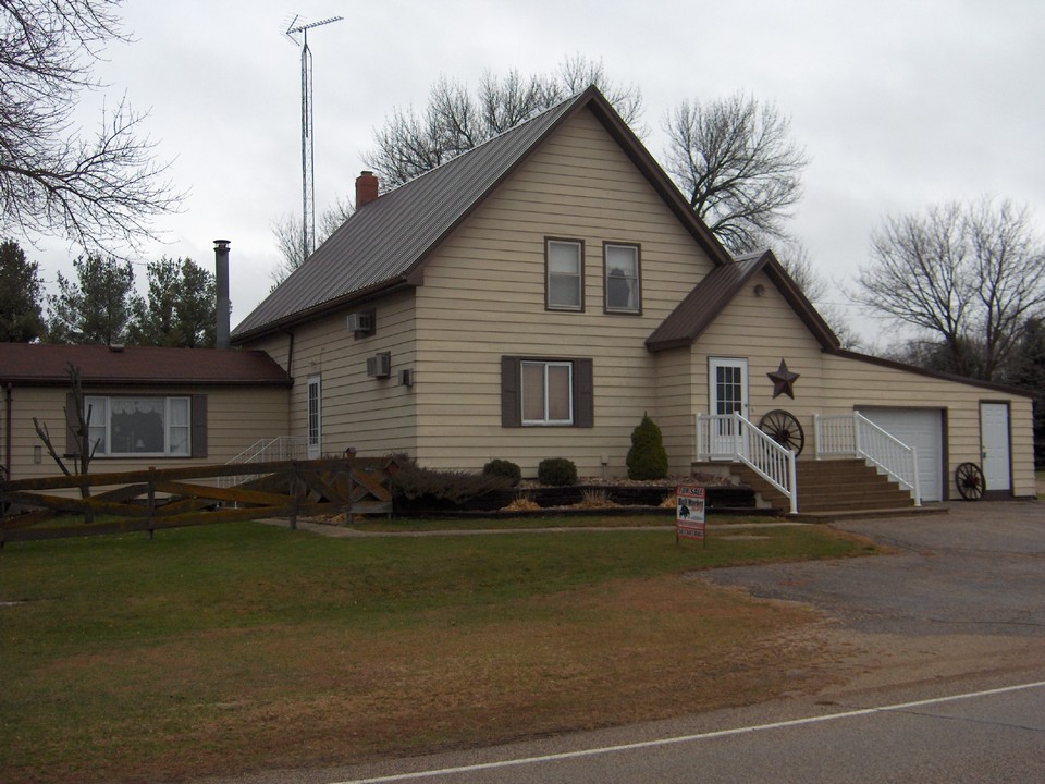 front of house steel siding, steel roof, attached garage, hard surfaced road