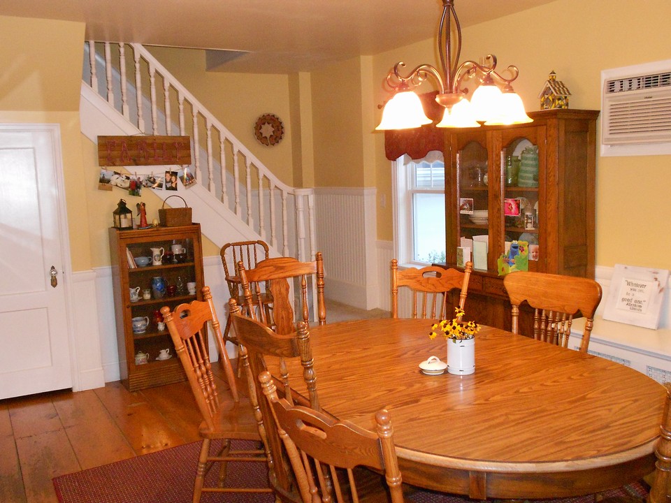 dining room nice wood floors and shows newer windows.  also, one of the staircases to second floor.