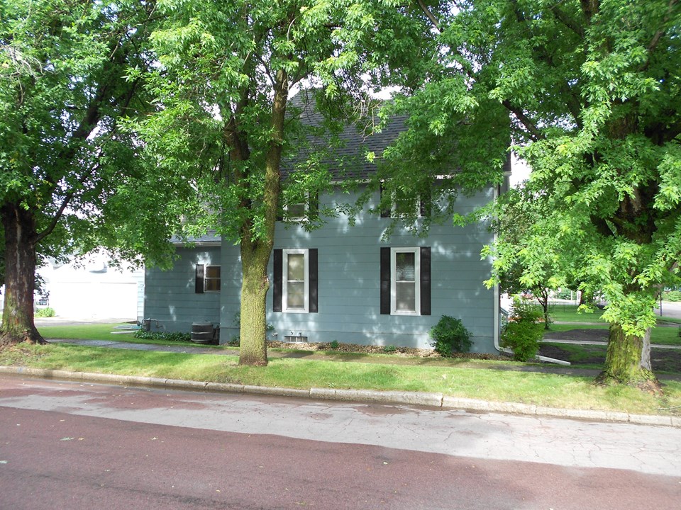 side view of house lots of mature trees for shade.