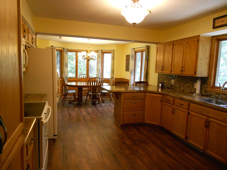 kitchen wide open to the dining area.  new floor, lighting, countertops, backsplash, and sink.  cabinets are custom built and have slide outs.  appliances will stay.