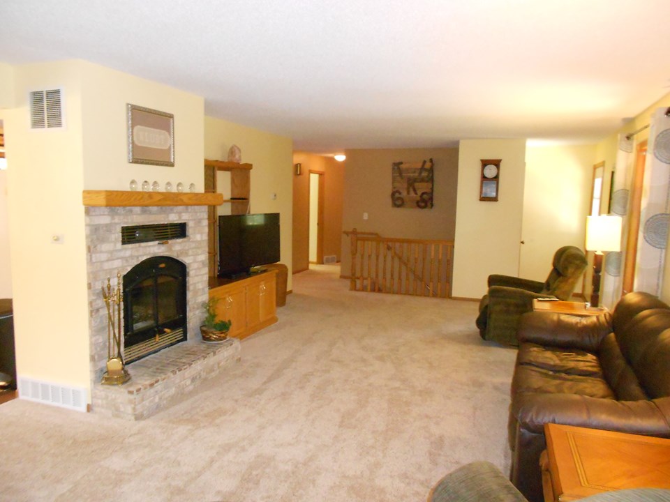 living room lots of space and a wood burning fireplace.