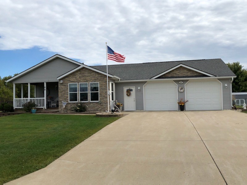 front of home corner lot, brick façade, landscaping, open porch, nice driveway, large garage.
