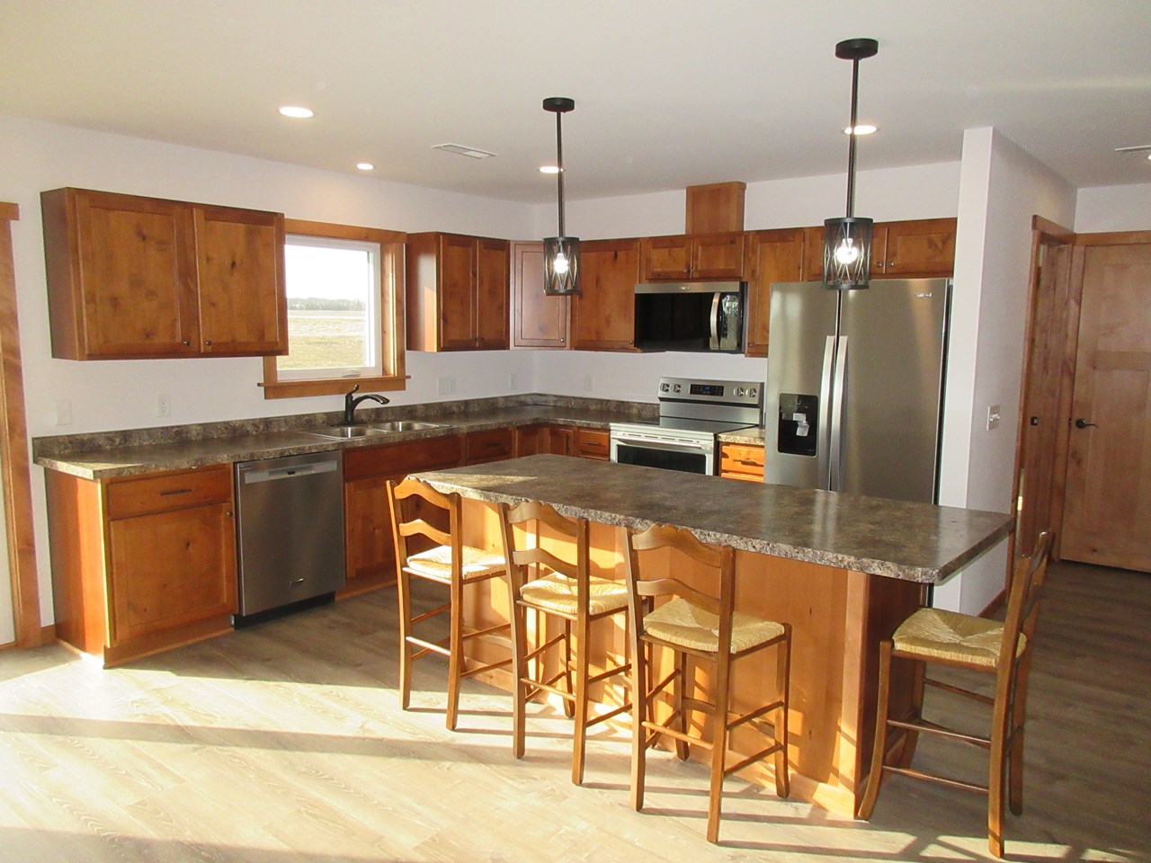 very modern kitchen with island brand new stainless steel appliances.